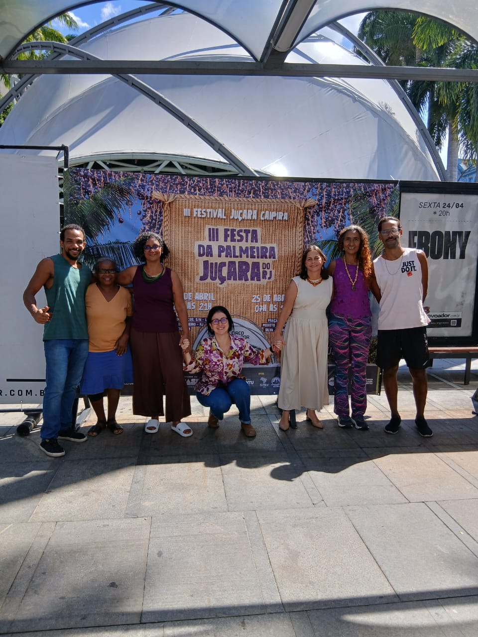 Equipe organizadora em frente ao cartaz da III Festa da Palmeira Juçara no Circo Voador