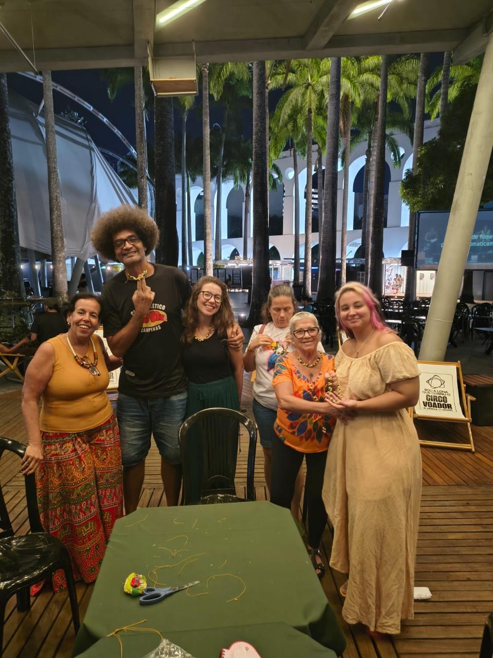 Participantes da oficina de artesanato com sementes de juçara no Circo Voador à noite