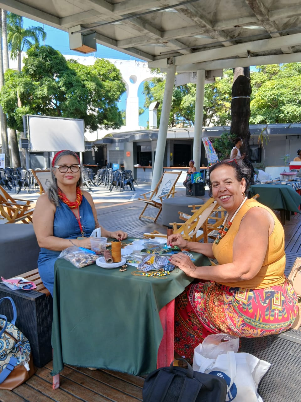 Grupo da Rede de Mulheres da Juçara reunido junto ao cartaz oficial da festa